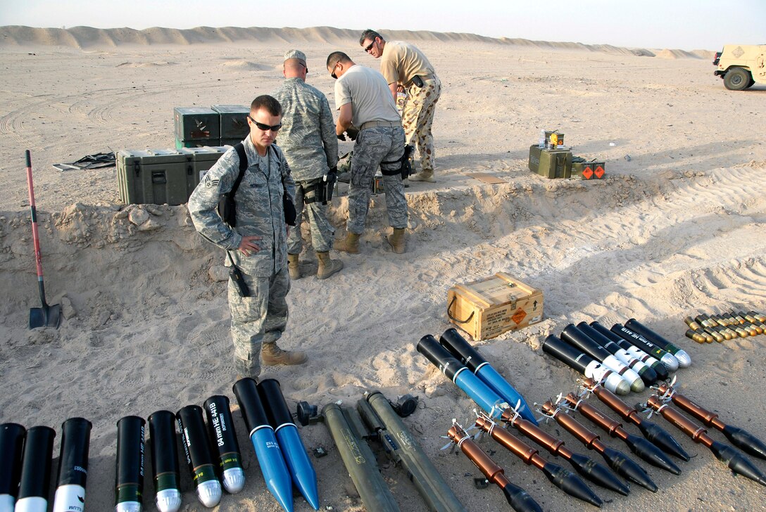 U.S. Air Force Senior Airman Charles Howell, front, looks over the munitions to be destroyed while other airmen and Australian army ammunition technicians prepare light anti-armor weapon rockets for disposal before a controlled detonation at an explosive ordnance disposal range in Southwest Asia, June 20, 2008.  
