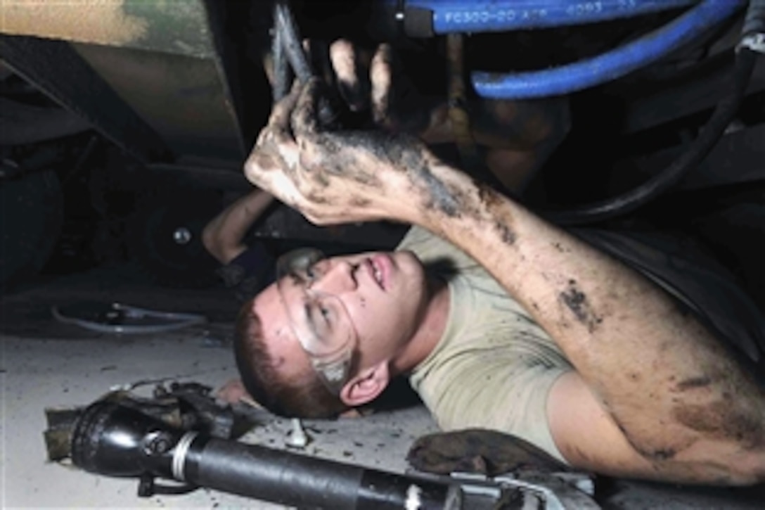 U.S. Air Force Senior Airman Anthony Dodge applies chaffe wrapping on hydraulic hoses while underneath a hydraulic test stand to prevent hoses from bursting, June 18, 2008, at a Southwest Asia air base. 