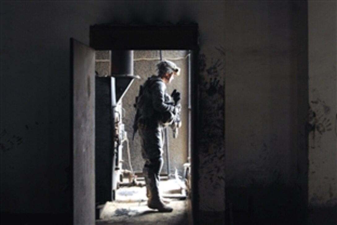U.S. Army Sgt. Michael Kearney, after conducting a search for weapons, stands in the doorway of a warehouse along Route Oregon in the Jamilla Market neighborhood of the Sadr City district of Baghdad, June 18, 2008. Kearney is assigned to the 1st Armored Division's Company C, 1st Battalion, 6th Infantry Regiment. 