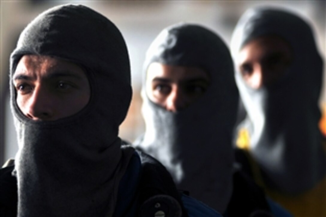 U.S. Navy Seaman Damian Doyle and other hose team members await instructions as they prepare to combat a simulated fire during a drill in the hangar bay aboard the aircraft carrier USS Abraham Lincoln, Persian Gulf, June 20, 2008. The USS Lincoln is deployed to the 5th Fleet area of responsibility to support maritime security operations. 