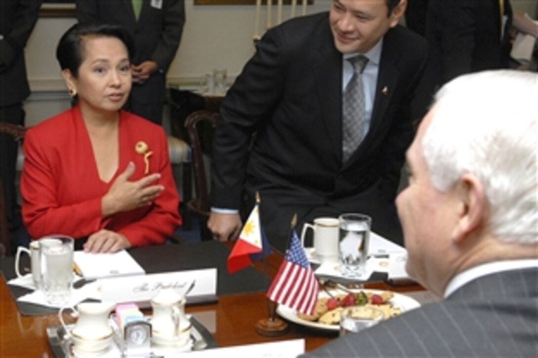 Philippine President Gloria Arroyo, back left, talks with U.S. Defense Secretary Robert M. Gates, foreground right, during a meeting in the Pentagon, June 24, 2008. 