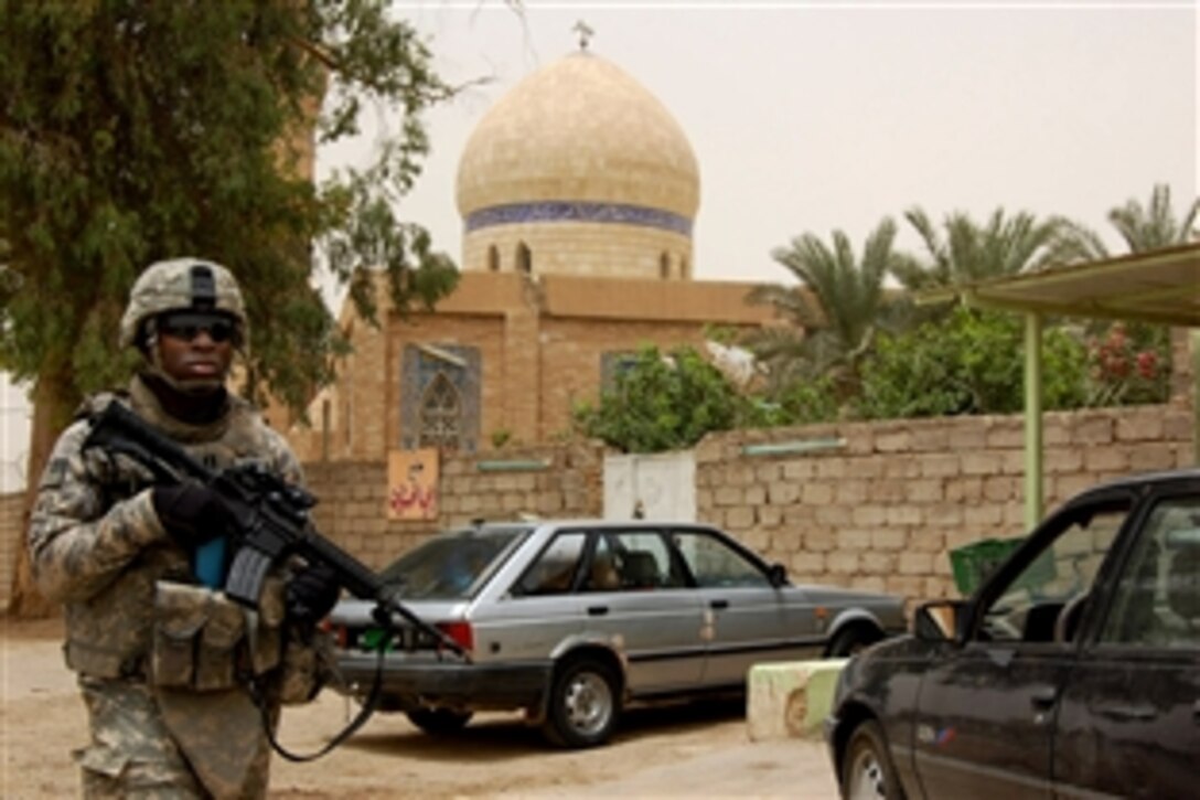 U.S. Army Capt. Omololu Makinde patrols past a mosque in Taji Qada, northwest of Baghdad, June 16, 2008, ensuring the residents in the region remain free of criminal activity. Makinde is the Iraqi security force coordinator for the 25th Infantry Division's 1st Battalion, 27th Infantry Regiment "Wolfhounds."
