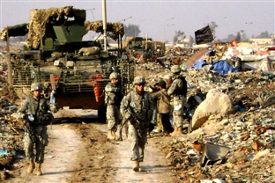 U.S. soldiers hand out water bottles to people who live in the landfill near Al Sabiat, a village northwest of Baghdad, June 15, 2008. The soldiers are assigned to the 25th Infantry Division's  2nd Squadron, 14th Cavalry Regiment, Multinational Division Baghdad, 