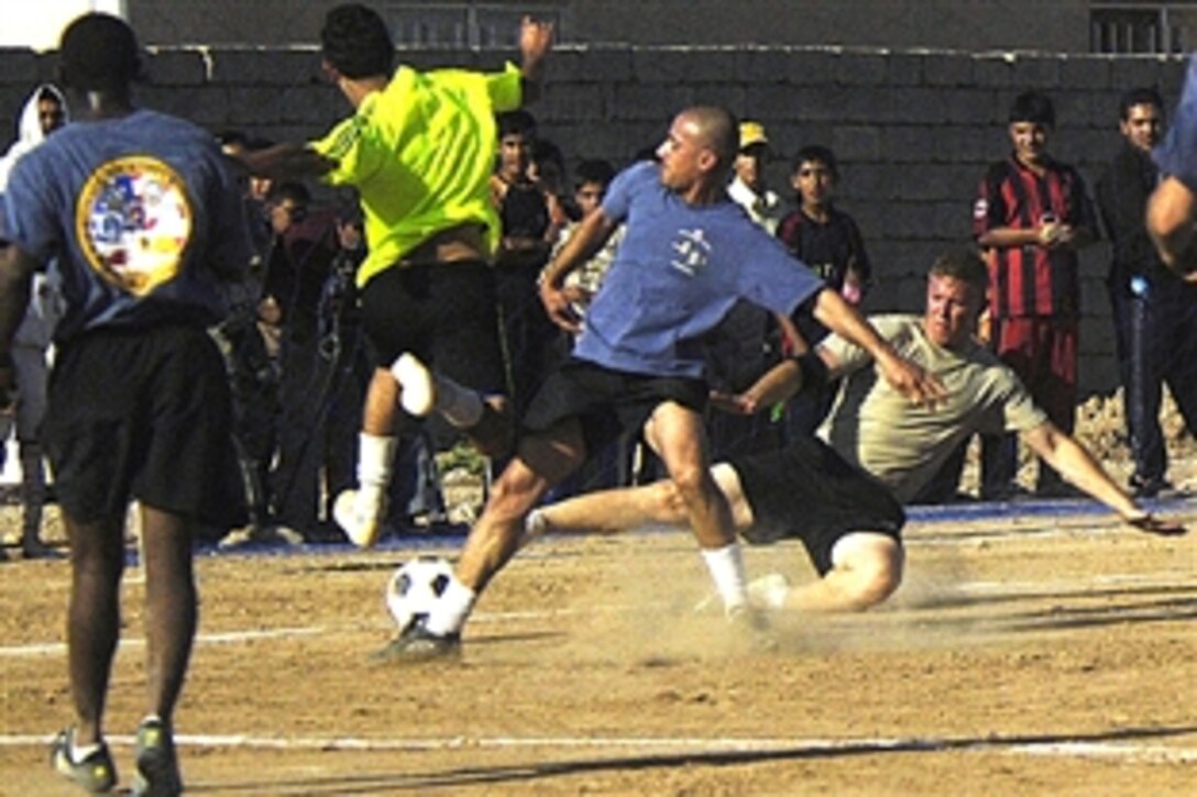 A U.S. Army soldier challenges a Sons of Iraq soccer player from scoring during a friendly game at the Multaka soccer field, June 19, 2008. The soliders are assigned to the 10th Mountain Division's 1st Battalion, 87th Infantry Regiment.