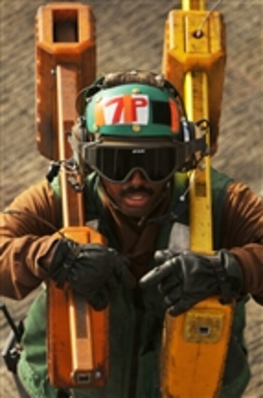 A U.S. Navy plane captain carries chocks to an aircraft on the flight deck aboard the Nimitz-class aircraft carrier USS Abraham Lincoln (CVN 72) while underway in the Persian Gulf on June 20, 2008.  The Lincoln is deployed to the U.S. 5th Fleet area of responsibility in support of maritime security operations.  
