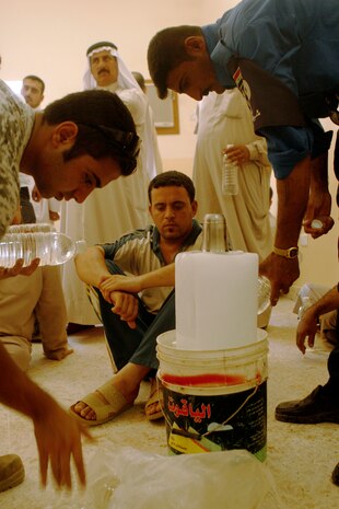 FALLUJAH, IRAQ  Iraqi Police provide ice and water to Fallujah residents waiting to receive a badge during a remote badging operation here, June 25. Enduring the hot weather and crowded lines, IPs managed to maintain the order for approximately 700 residents who received new IDs, which are necessary to enter and exit the city. (Official U.S. Marine Corps photo by Cpl. Chris Lyttle) (RELEASED)