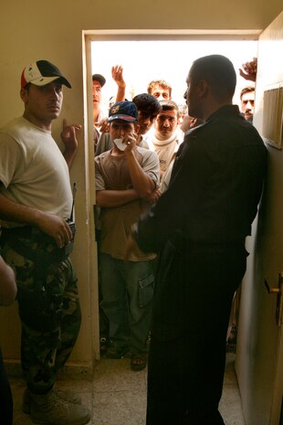 FALLUJAH, IRAQ  Iraqi Police open the door to a large crowd of Fallujah residents who came to receive badges during a remote badging operation here, June 25. 3rd Battalion, 6th Marines and IPs worked together to service approximately 700 residents with valid IDs to enter and exit the city. (Official U.S. Marine Corps photo by Cpl. Chris Lyttle) (RELEASED)