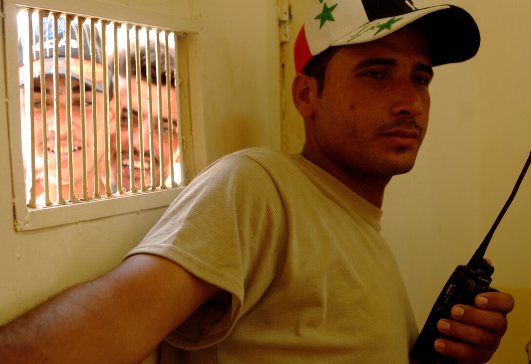 FALLUJAH, IRAQ An Iraqi Police officer in the southern portion of Fallujah, controls the doorway where Fallujah residents came to receive new badges during a remote badging operation here, June 25. Crowd control was a major task for the IPs, making sure the residents maintained good order while waiting in long lines in hot temperatures. (Official U.S. Marine Corps photo by Cpl. Chris Lyttle) (RELEASED)