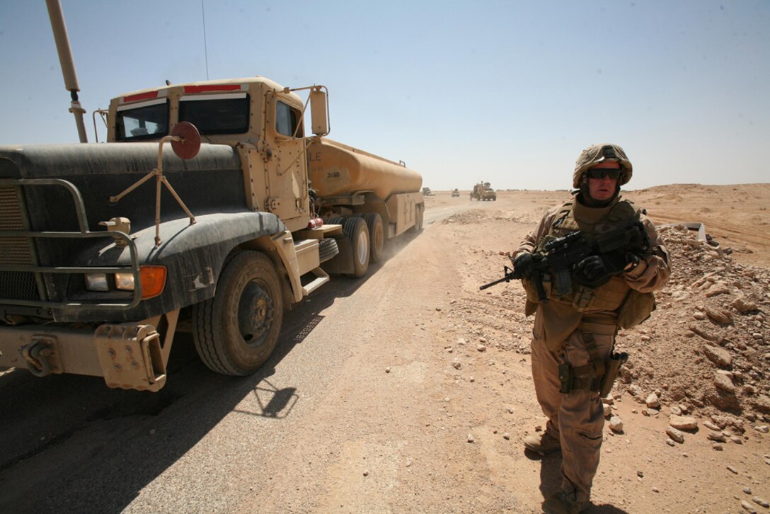 Sergeant Greg G. Mosher, motor transport chief for Task Force Hit, 3rd Battalion, 4th Marine Regiment, Regimental Combat Team 5, provides security as a resupply truck passes a small bridge in western Al Anbar province, Iraq, July 1. Motor T Marines have assisted companies within the battalion by providing supplies they need. Despite operating in a large area of operations, the Marines have completed their mission in Iraq with no problems. ::r::::n::