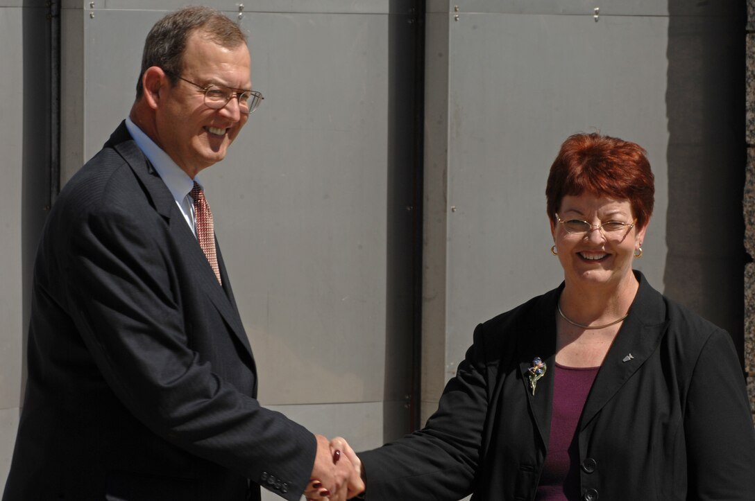 Richard Gustafson, Air Force Financial Operations deputy assistant secretary, congratulates Joan Causey, Air Force Financial Services director, upon her induction into the ranks of the Senior Executive Service at Mount Rushmore, June 24. Ms. Causey oversees military pay and travel reimbursements for all Air Force active-duty, civilian and Reserve personnel. (U.S. Air Force photo/Airman Corey Hook)