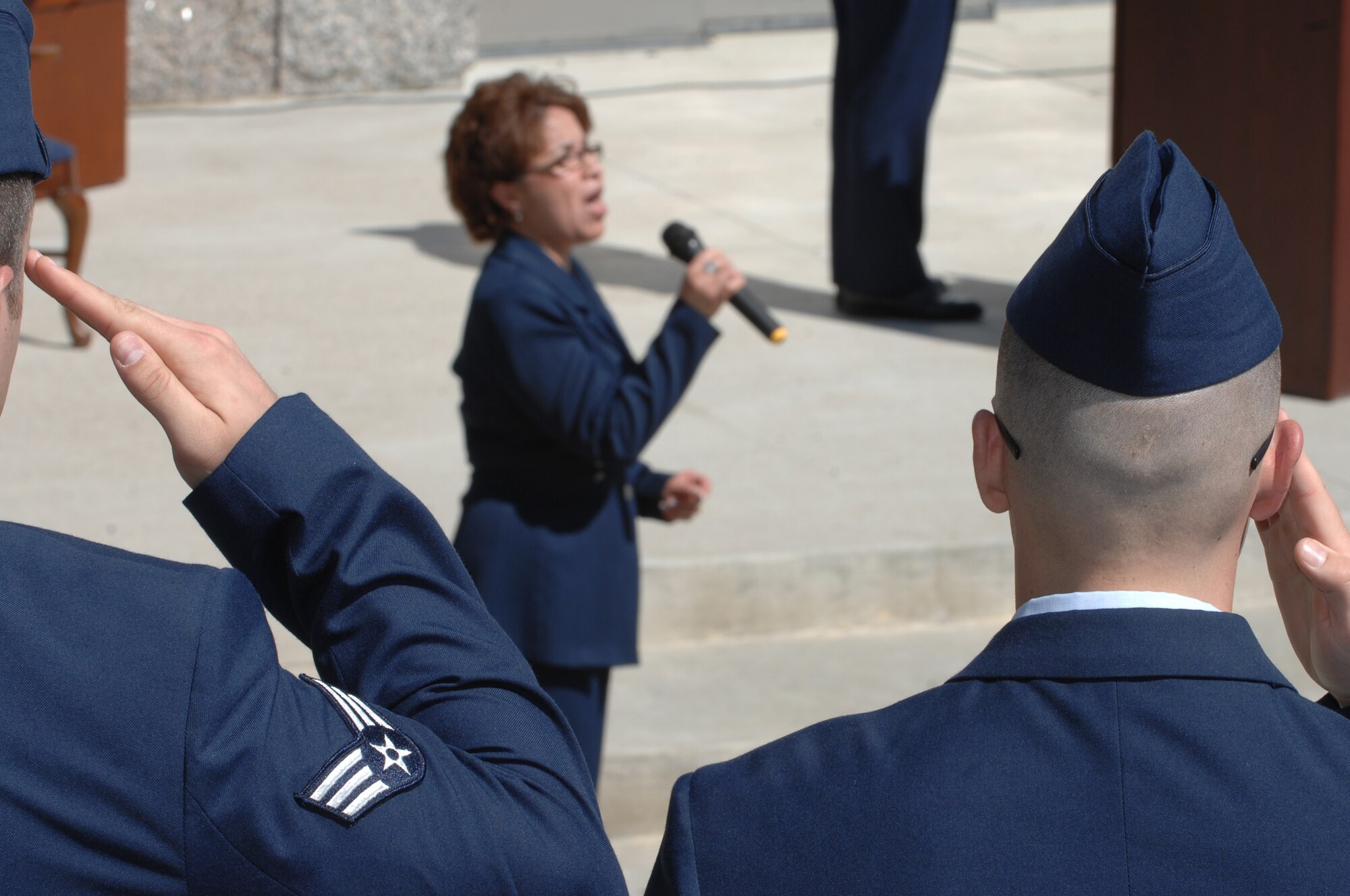 Nelda Barrientes, 28th Comptroller Squadron secretary, sings the National Anthem in the beginning of an induction ceremony at Mount Rushmore, June 24. The ceremony inducted Joan Causey, Air Force Financial Services director, into the ranks of the Senior Executive Service. (U.S. Air Force photo/Airman Corey Hook)