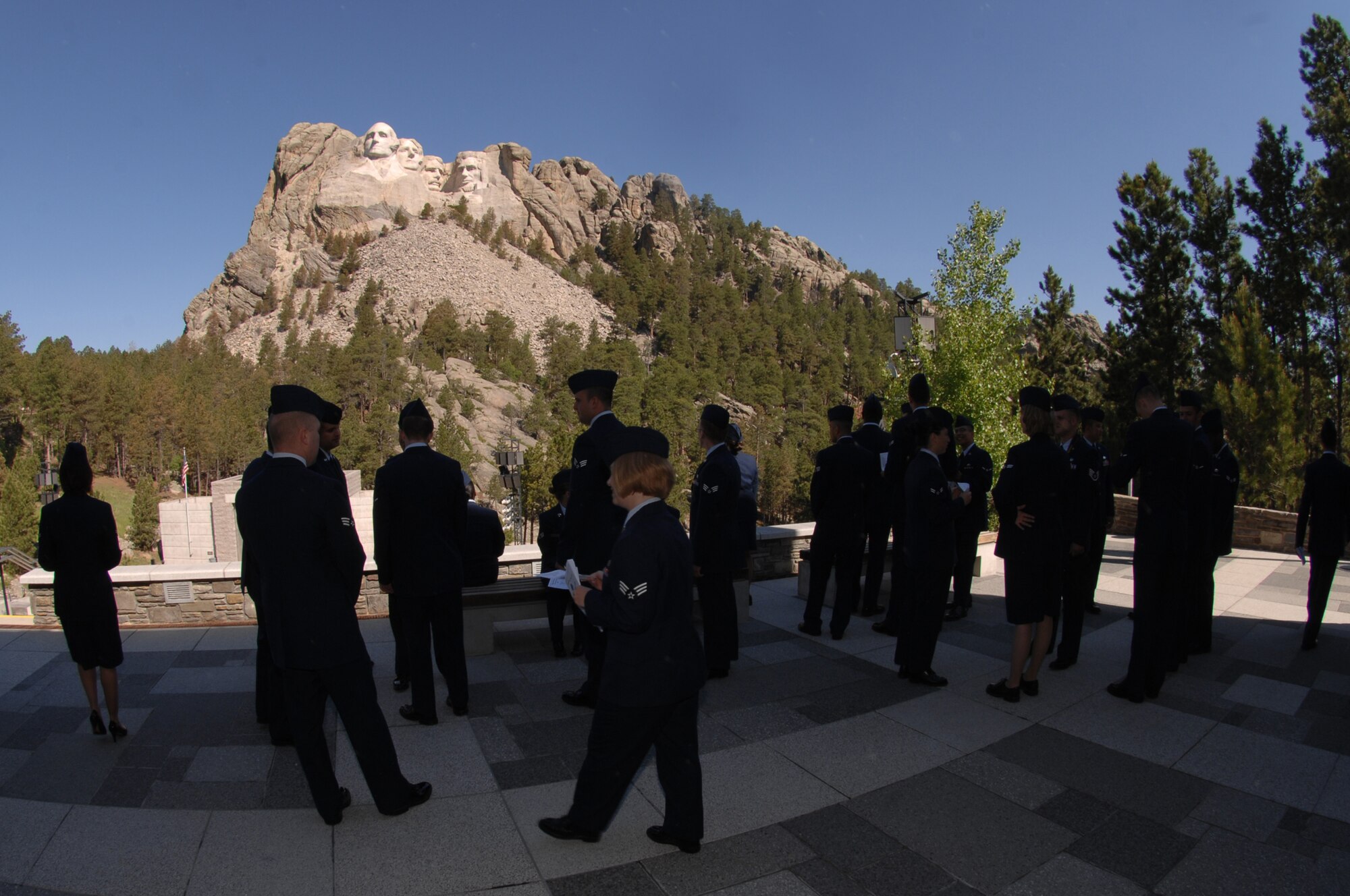 Airmen admire Mount Rushmore while awaiting the beginning of Joan Causey's, Air Force Financial Services director, induction into the Senior Executive Service ranks at Mount Rushmore, June 24. Ms. Causey was presented a coin and officially inducted by Richard Gustafson, Air Force Financial Operations deputy assistant secretary. (U.S. Air Force photo/Airman Corey Hook)