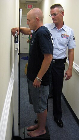 Tech. Sgt. Christopher Conaway weighs Matt Mobley at the Summerville, S.C., recruiting office June 23. Mr. Mobley started out 253 pounds when he started the process of joining the Air Force and lost nearly 90 pounds in eight months and currently weighs 164. Mr. Mobley will be leaving for Basic Military Training July 1 and Sergeant Conaway is his local recruiter. (U.S. Air Force photo/Airman 1st Class Melissa White)