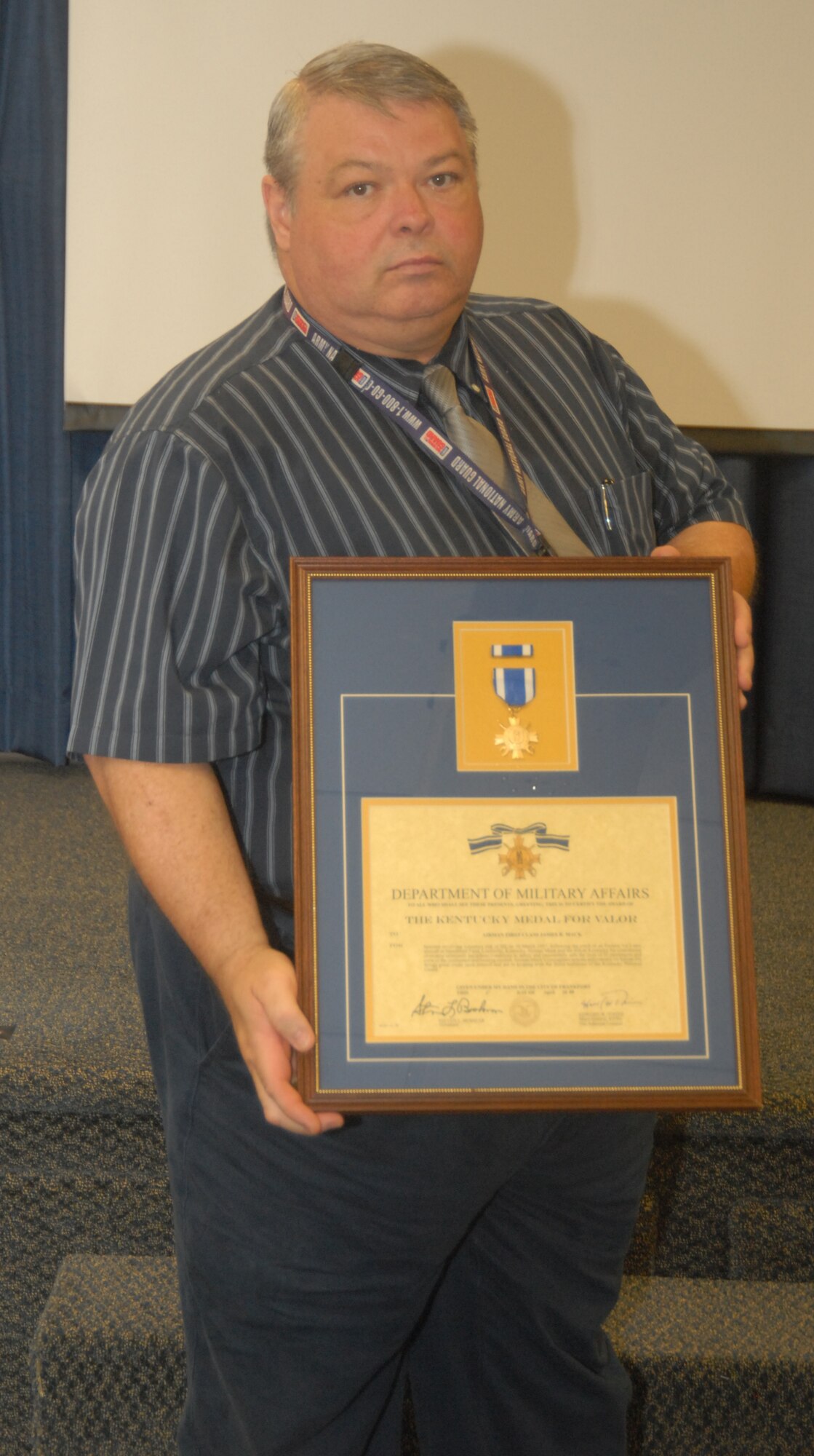 Command Historian holds the Kentucky Medal of Valor citation awarded to Airman First Class James R. Mack (not present) for his heroic actions on March 10, 1957, following the crash of an Eastern Airlines passenger aircraft at Standiford Field in Louisville - photo by Tech. Sgt. Philip S. Speck