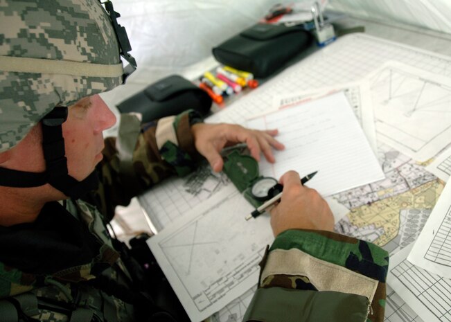 Tech. Sgt. Gary Reash lays out compiled range coordinates, or "sector sketches," during the mobility exercise June 24 on Charleston AFB. Airmen from across the base are participating in a mobility exercise in preparation for the Headquarters Air Mobility Command operational readiness inspection in August. Sergeant Reash is the NCO in charge of operations for the 437th Security Forces Squadron.  (U.S. Air Force photo/Airman 1st Class Timothy Taylor)