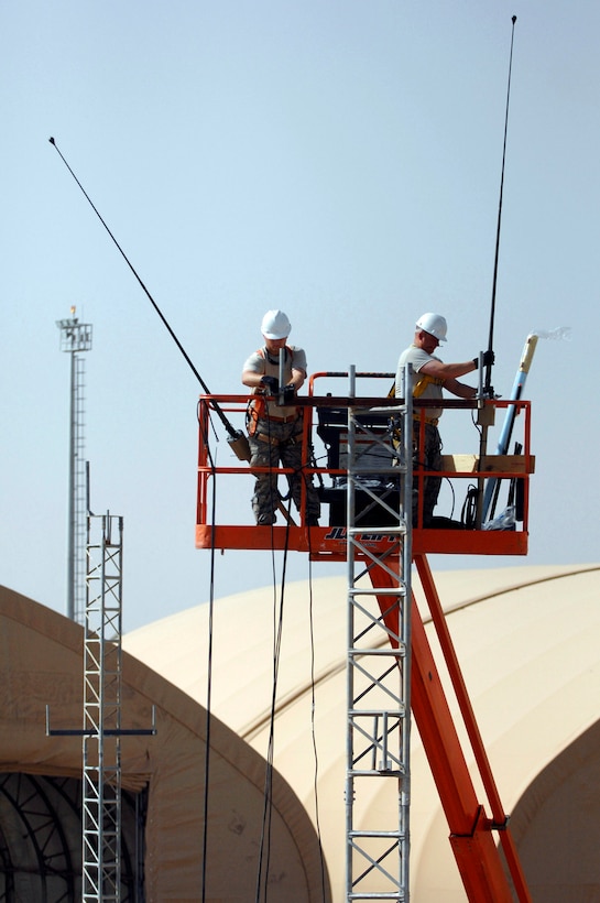 Senior Airman Paul Martin and Tech. Sgt. Robert Fisher install high-frequency radio antennas which will be used for future ground-to-air tactical radio communications and provide more land mobile radio capabilities for ground operations June 21 at Joint Base Balad, Iraq. The Airmen are 332nd Expeditionary Communications Squadron ground radio maintainers. Airman Martin is deployed from Yokota Air Base, Japan, and Sergeant Fisher is deployed from Youngstown Air Reserve Base, Ohio. (U.S. Air Force photo/Senior Airman Julianne Showalter) 