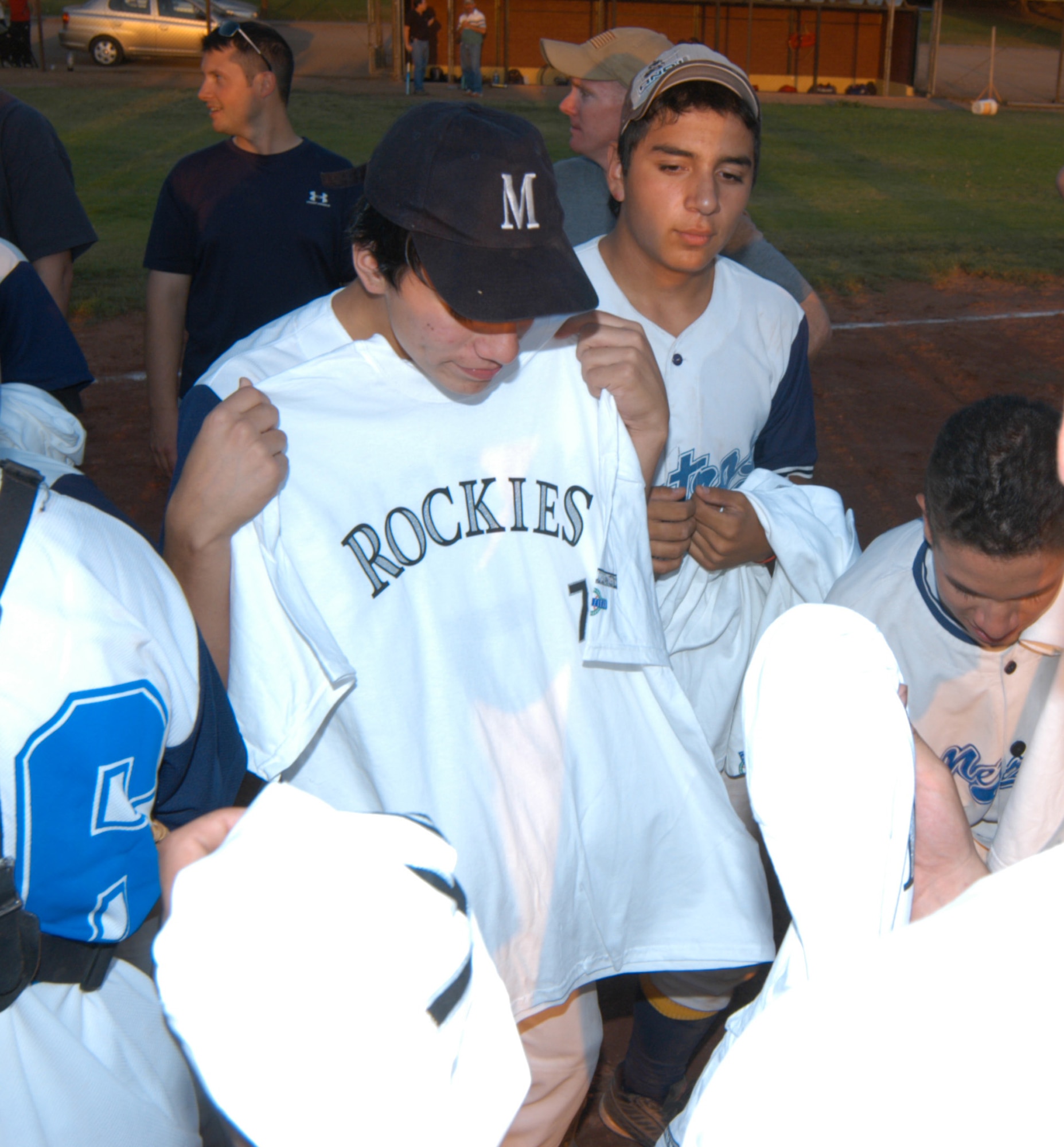 Players for the Santiago Metros semi-pro baseball team admire shirts gifted to them by the Colorado Rockies professional baseball team. The Rockies are involved with Major League Baseball International, and were excited over the opportunity to be included in the game between U.S. Airmen and the Metros. (U.S. Air Force photo/Master Sgt. Jason Tudor).                                