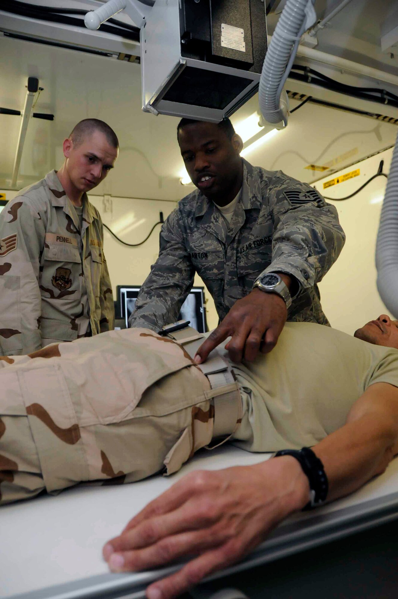 Master Sgt. Will Brown shows Staff Sgt. Enzzo Ferrari some of the tasks of a C-17 Globemaster III loadmaster June 24 in Southwest Asia. The two are participating in a mentor/shadow program designed to help younger Airmen who are deployed make major career decisions while far away from career advisors and other personnel specifically trained to help in those areas. Sergeant Ferrari is interested in cross-training from the 379th Expeditionary Operations Support Squadron. Sergeant Brown is a member of the 816th Expeditionary Airlift Squadron. (U.S. Air Force photo/Senior Airman Domonique Simmons) 
