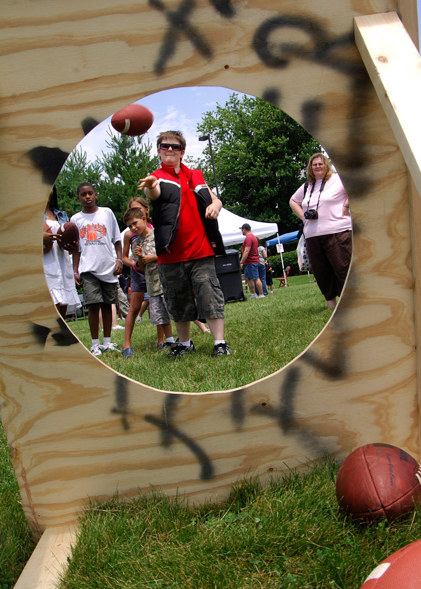 SCOTT AIR FORCE BASE, Ill. -- A.J. Lindsay throws a football through the target at a game booth at the Match Up picnic. The football toss game was just one of many games and activities that were there for members of Joint Total Force Scott and their families to participate in. 
(US Air Force photo/Airman 1st Class Wesley Farnsworth)
