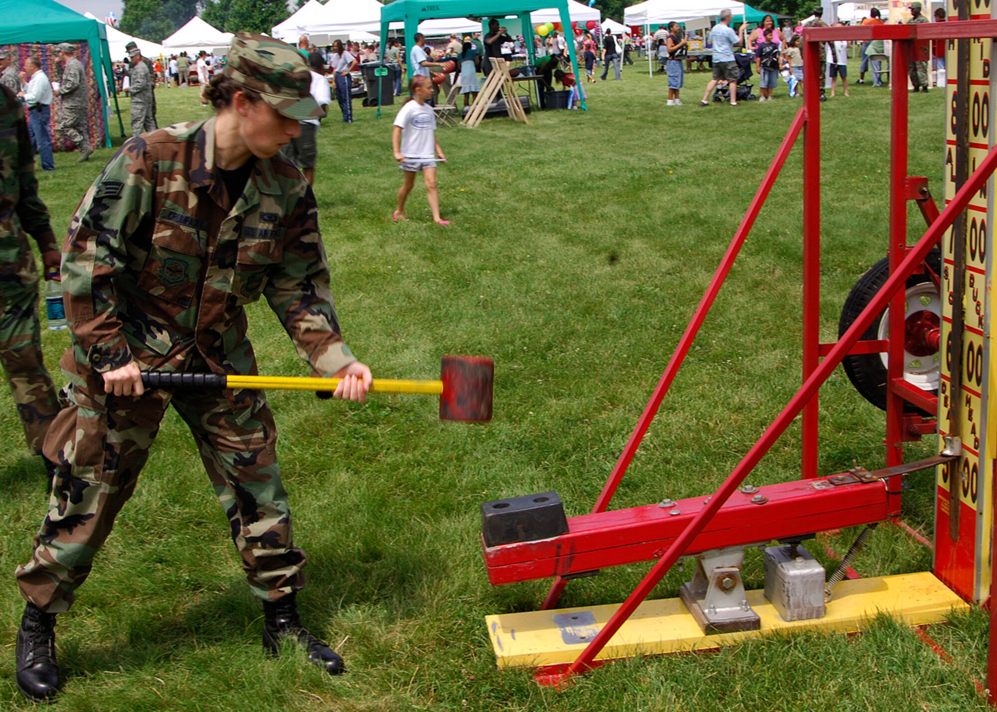 SCOTT AIR FORCE BASE, Ill. -- Senior Airman Faith Crumpecker, 932nd Aerospace Medical Squadron medical evacuation technician, swings the oversized hammer in an effort to send the slider up to the bell at a strength game during the Match Up Picnic. 
(US Air Force photo/Airman 1st Class Wesley Farnsworth)