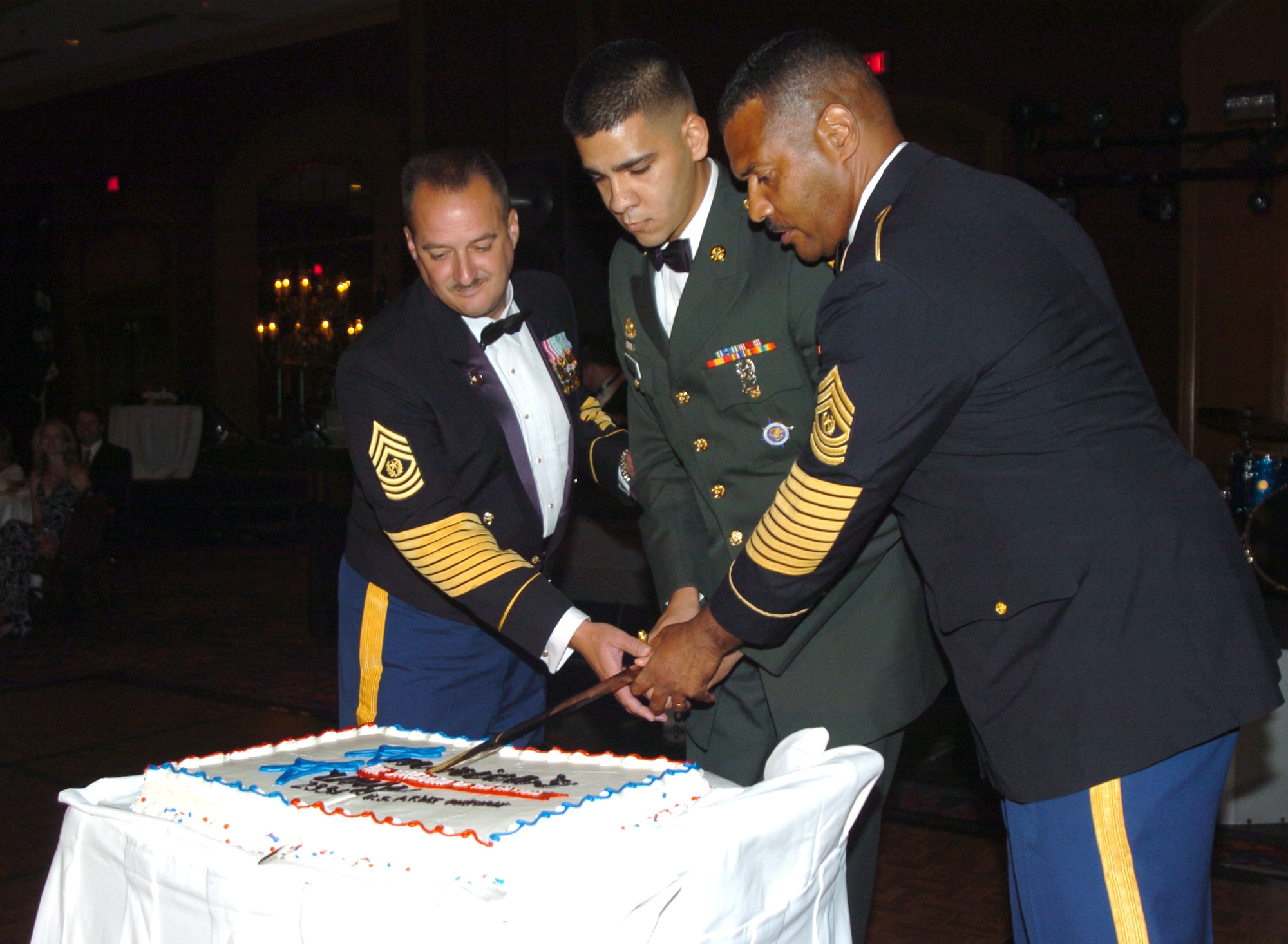 SCOTT AIR FORCE BASE, Ill. -- Command Sgt. Maj. Tracey Barlogio, St. Louis Human Resources Command, Sgt. Steven Hernandez, U.S. Transportation Command NCO of the Year, and Command Sgt. Maj. Tomás Hawkins, Surface Deployment and Distribution Command command sergeant major, cut the cake for the U.S. Army's 233rd Birthday Ball June 14.
(photo/Mike Petersen)