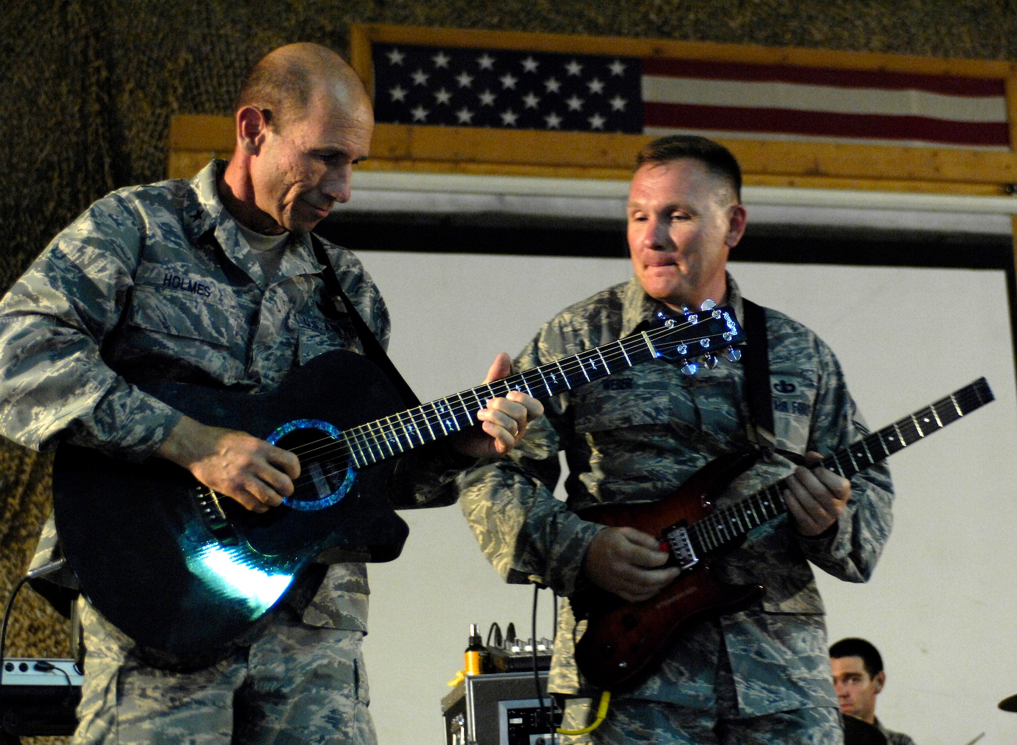 BAGRAM AIR FIELD, Afghanistan – Brig. Gen. Mike Holmes, 455th Air Expeditionary Wing commander, delivers a ‘star’ performance as Senior Master Sgt. James Weber, U.S. Air Forces Band ‘Falcon’ vocalist and guitarist, looks on during the band’s show here June 22.  ‘Falcon’ travels throughout the area of responsibility positively promoting troop morale, diplomacy and reach out to host nation communities.  (U.S. Air Force photo by Master Sgt. Demetrius Lester)
