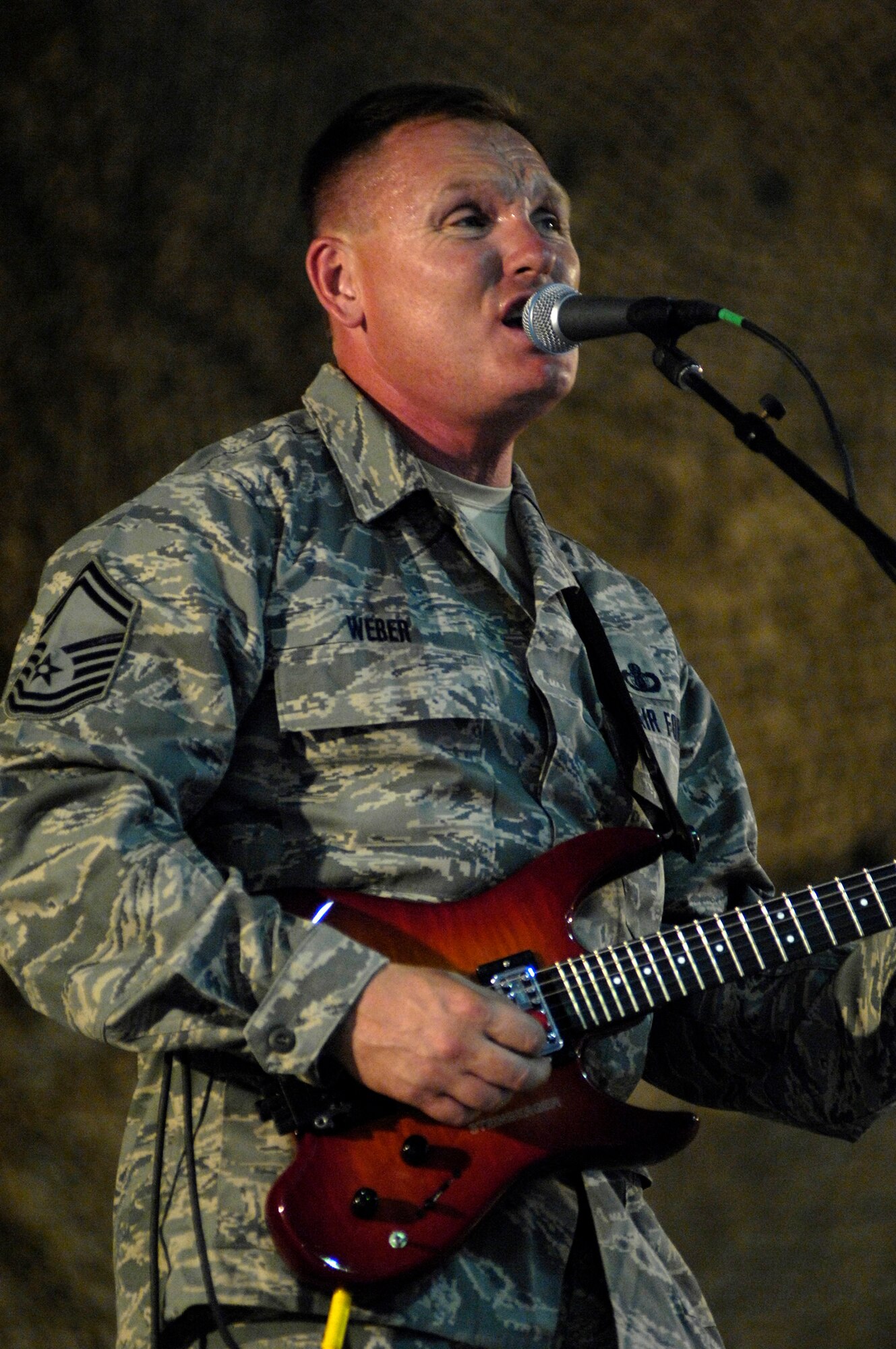 BAGRAM AIR FIELD, Afghanistan – Senior Master Sgt. James Weber, U.S. Air Forces Band ‘Falcon’ vocalist and guitarist, sings during a show here June 22.  ‘Falcon’ travels throughout the area of responsibility positively promoting troop morale, diplomacy and reach out to host nation communities.  (U.S. Air Force photo by Master Sgt. Demetrius Lester)
