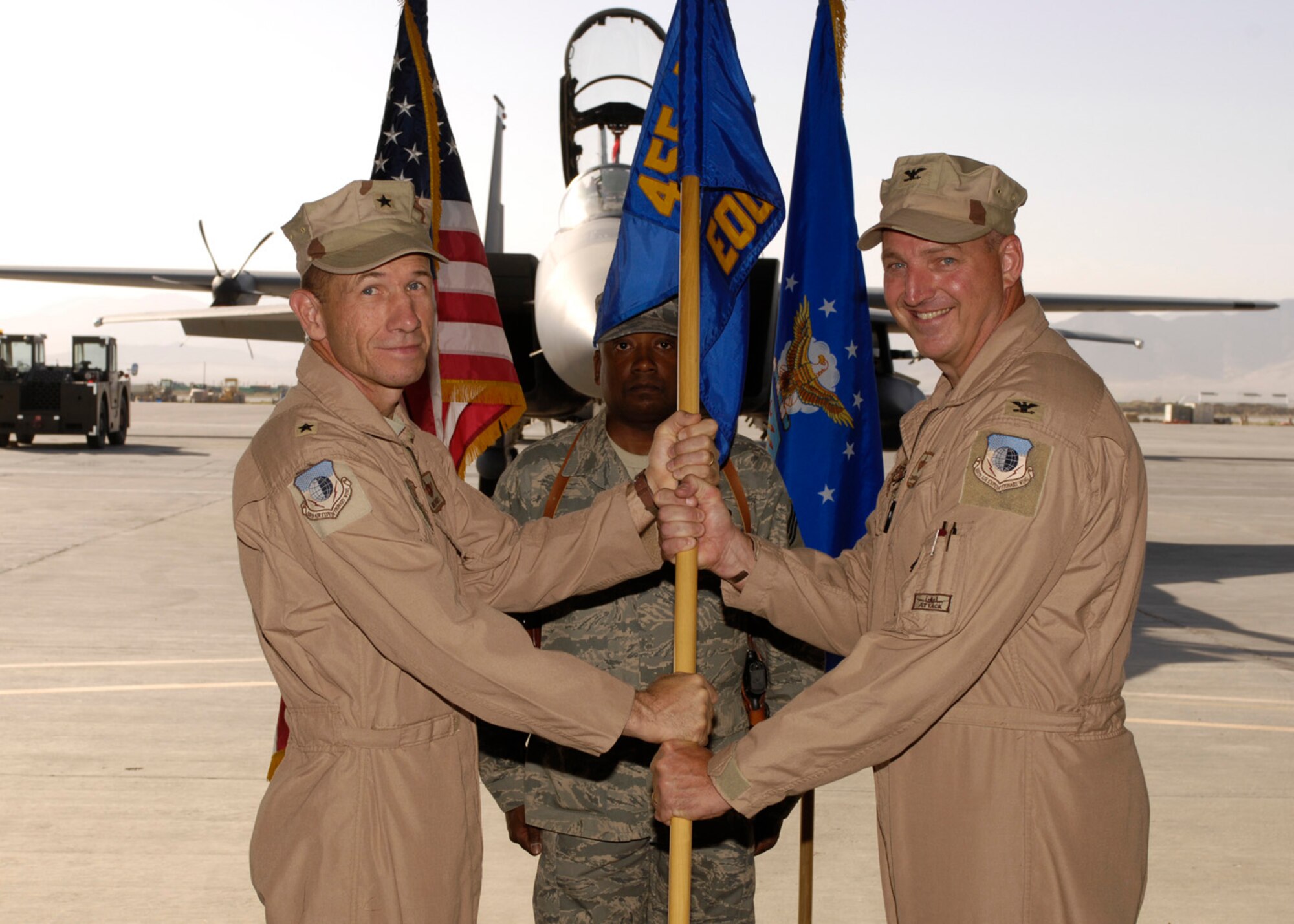 BAGRAM AIR FIELD, Afghanistan -- Col. Tim “Donk” Strasburger (right), 455th Expeditionary Operations Group commander, accepts the guidon and responsibility of the group, from Brig. Gen. Mike Holmes, 455th Air Expeditionary Wing commander, here June 21. (U.S. Air Force photo by Master Sergeant Demetrius Lester)