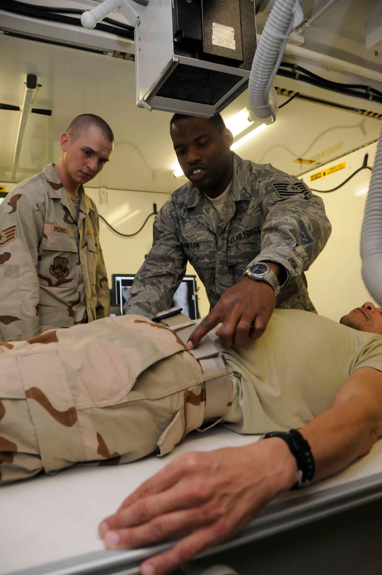 SOUTHWEST ASIA--Tech. Sgt. Robert Barton, 379th Expeditionary Medical Group, shows Staff Sgt. Jacob Pennell, 379th Expeditionary Maintenance Squadron, some radiology procedures at the medical group here June 24 as part of the Mentor/Shadow Program. (U.S. Air Force photo/ Senior Airman Domonique Simmons)