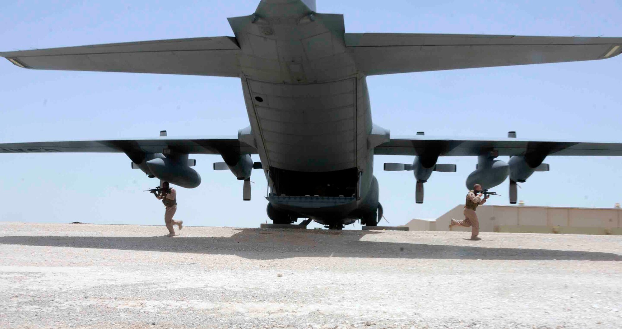 SOUTHWEST ASIA—Staff Sgt. Nahteas Murphy (left) and Senior Airman David Mattox (right) hustle out of the rear of a C-130 aircraft to post and secure a perimeter June 24. Sergeant Murphy and Airman Mattox belong to the 379th Expeditionary Security Forces Squadron's Fly Away Security Team. They fly with aircrew and land in undisclosed locations to provide security to U.S. Air Force, and U.S. military resources. (U.S. Air Force photo/ Senior Airman Domonique Simmons)