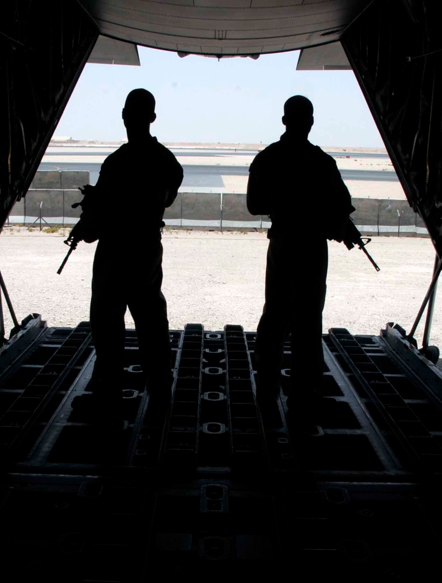 SOUTHWEST ASIA— Staff Sgt. Nahteas Murphy and Senior Airman David Mattox survey their surroundings before proceeding from the rear of a C-130 June 24. Both U.S. Air Force members are apart of the Fly Away Security Team assigned to the 379th Expeditionary Security Forces Squadron (U.S. Air Force photo/ Senior Airman Domonique Simmons)