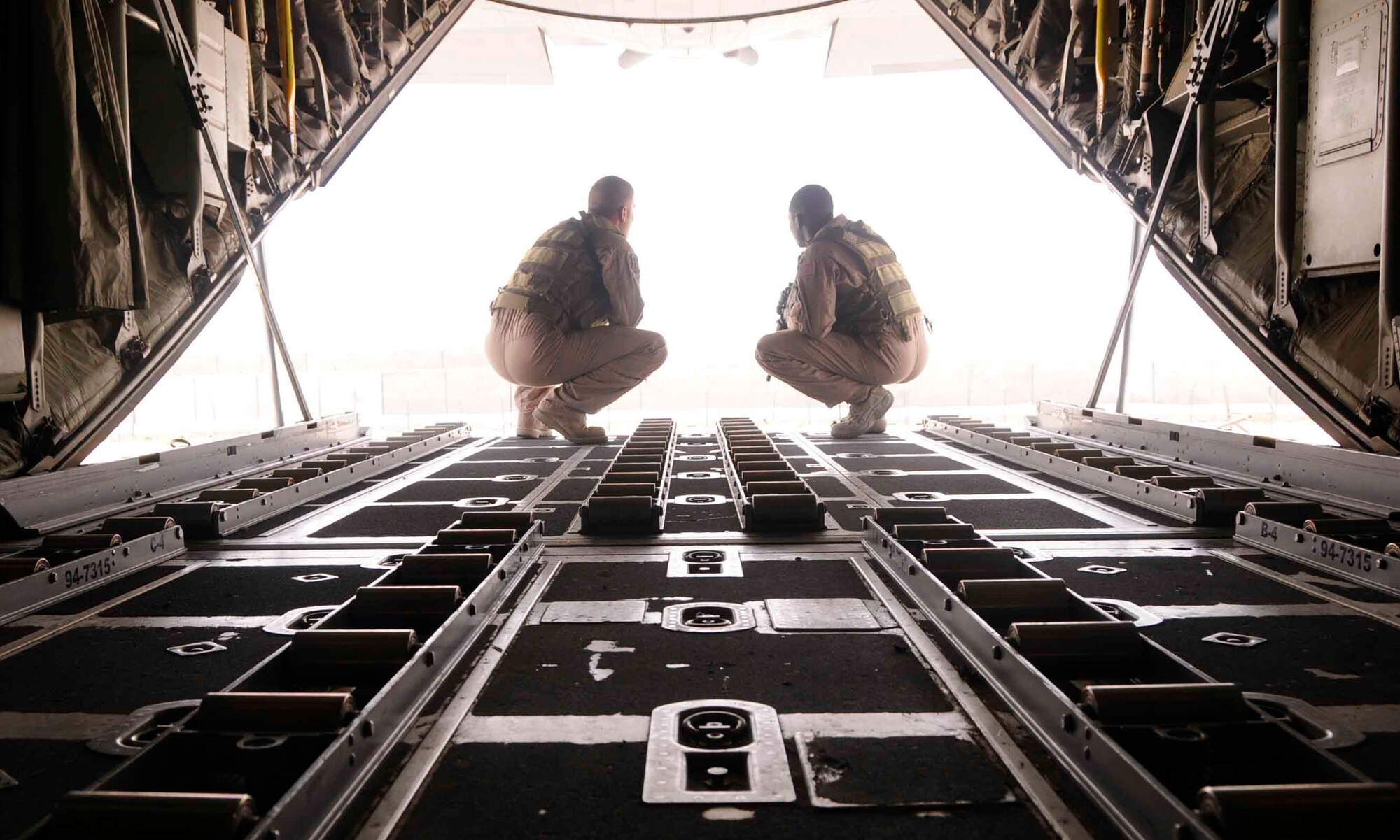 SOUTHWEST ASIA— Staff Sgt. Nahteas Murphy and Senior Airman David Mattox survey their surroundings before proceeding from the rear of a C-130 June 24. Both U.S. Air Force members are apart of the Fly Away Security Team assigned to the 379th Expeditionary Security Forces Squadron (U.S. Air Force photo/ Senior Airman Domonique Simmons)