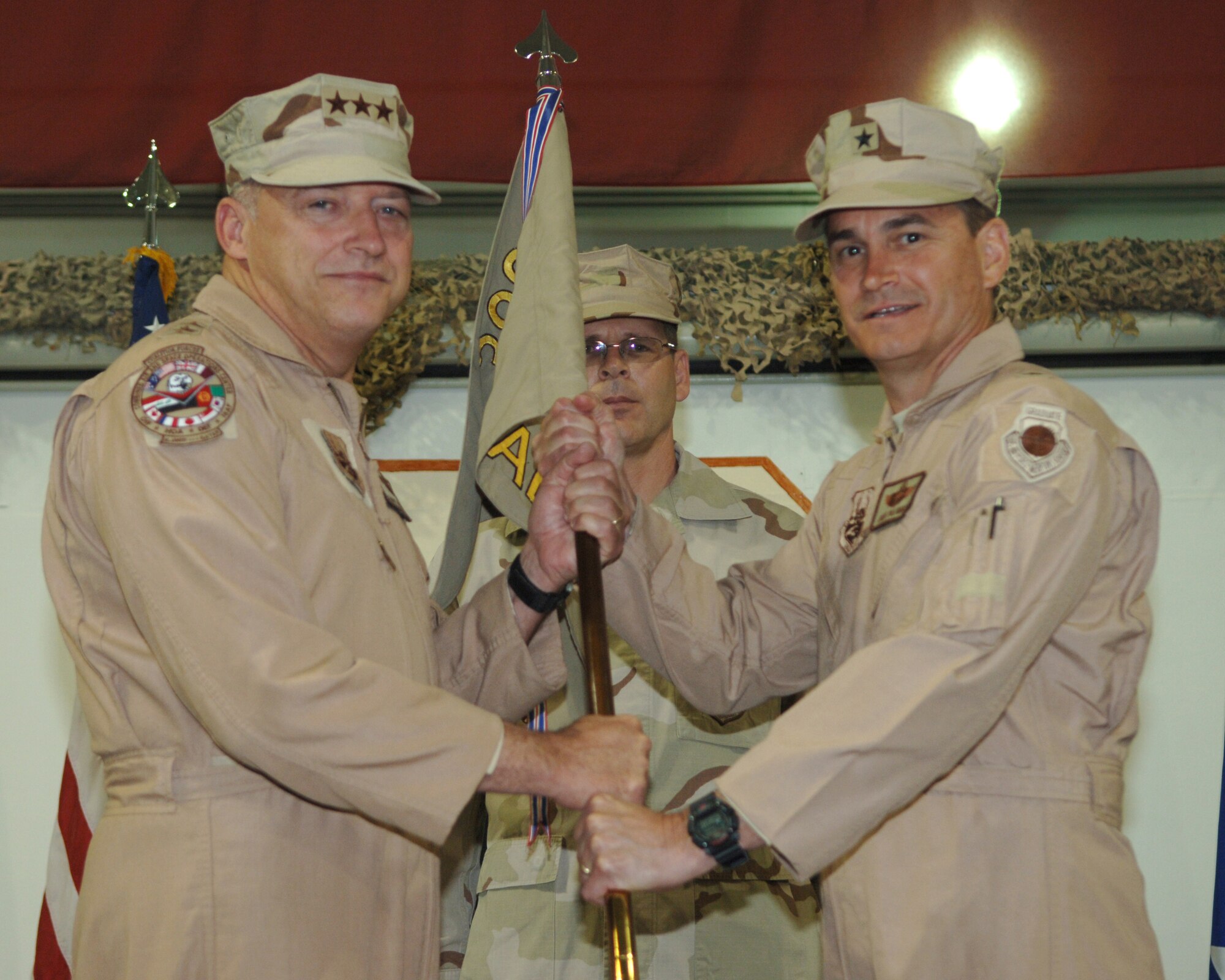 Brig. Gen. H.D. Polumbo, Jr., 380th Air Expeditionary Wing commander, receives the wing guidon from Lt. Gen. Gary North, Ninth Air Force and U.S. Air Forces Central commander, during the wing change of command ceremony, June 16.(U.S. Air Force photo/Airman 1st Class Kelly LeGuillon)
