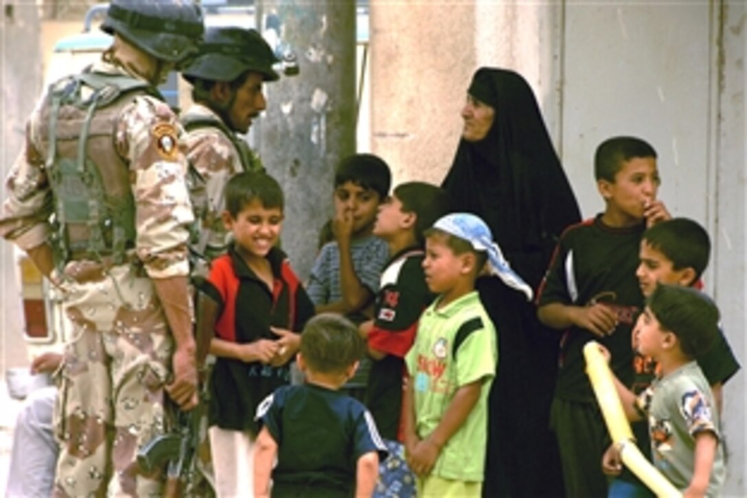 Iraqi soldiers speak to a local resident and children while conducting a population survey during a combined patrol with U.S. soldiers in the Shula district of Baghdad, Iraq, June 18, 2008. The U.S. soldiers are assigned to the 101st Airborne Division's Bravo Troop, 1st Squadron, 75th Cavalry, 2nd Brigade Combat Team. 