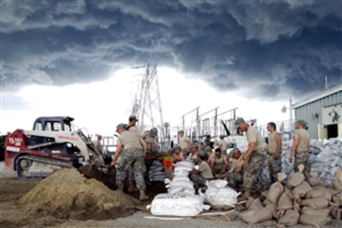Army National Guard soldiers from Iowa work to complete a seven-foot sandbagged levy in order to protect an electrical generator from the rising floodwaters in Hills, Iowa, June 14, 2008. About 80 guardsmen -- including those with the 34th Army Band out of Fairfield --  sandbagged at the generator plant.
