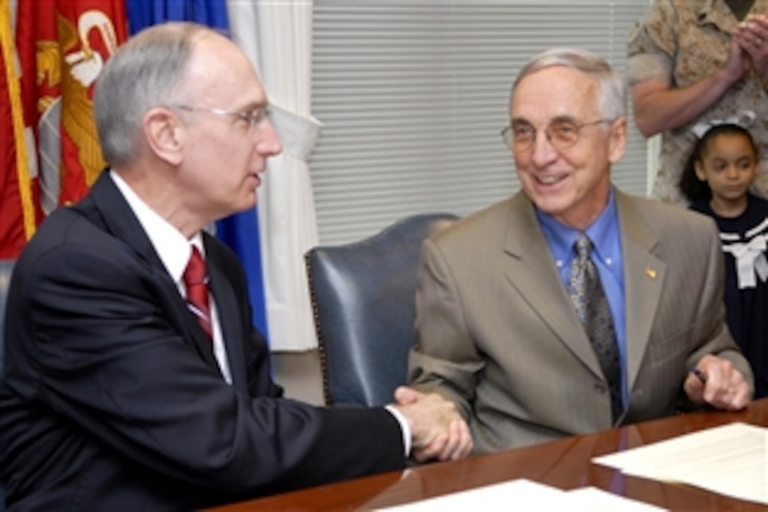 Deputy Secretary of Education Raymond Simon, left, and Deputy Secretary of Defense Gordon England shake hands after signing a memorandum of understanding on military education during a ceremony at the Pentagon, June 25, 2008. The document is intended to promote better education opportunities for military children.