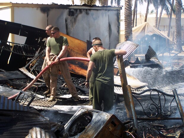 FALLUJAH, Iraq (June 25, 2008) â?? Company L, 3rd Battalion, 6th Marines water down smoldering from a fire that destroyed the Marine compound at Entry Control Point-5 (ECP-5), June 25. The fire spread throughout the post and burned down every wooden hut, leaving most of the Marines without equipment or personal possessions. The company said it has received generous support from local Iraqis, neighboring units and stateside supporters to recover from this incident. (Official U.S. Marine Corps photo by Company L, 3rd Battalion, 6th Marines) (RELEASED)