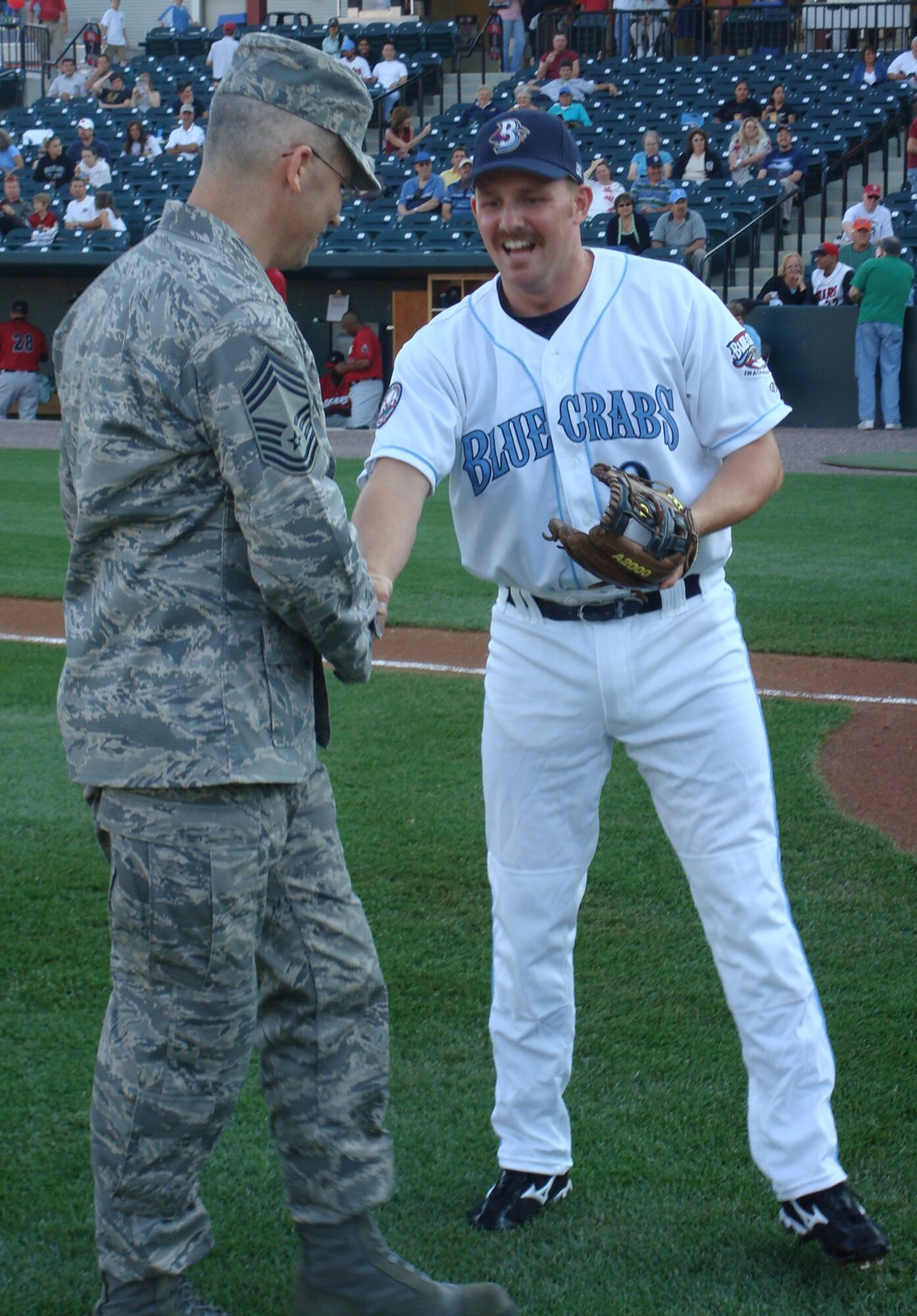 Chief Master Sgt. Timothy Tate shakes hands with Christopher Maples, Southern Maryland Blue Crabs infielder June 17at Regency Furniture Park, Waldorf, Md. Chief Tate threw out the first pitch for the Blue Crabs. Chief Tate is the interim 316th command chief master sergeant. The Blue Crabs beat the Newark Bears 10-2. (Courtesy photo)
