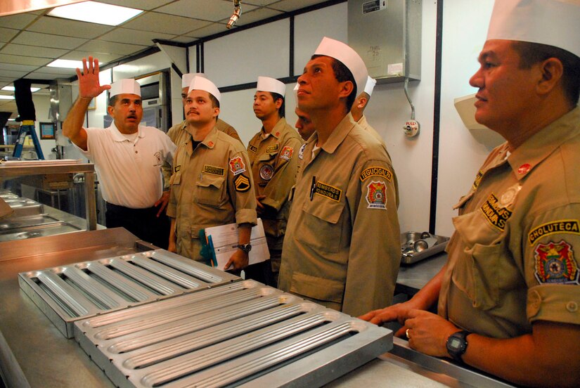 SOTO CANO AIR BASE, Honduras--Joint Task Force-Bravo fire inspector Mr. Herberth Gaekel (left) explains how the JTF-Bravo dining facility fire suppression works to Honduran fire inspectors here for a JTF-Bravo-sponsored firefighting subject matter expert exchange which focuses on facility inspection and fire investigation procedures. (U.S. Air Force photo by Tech. Sgt William Farrow)