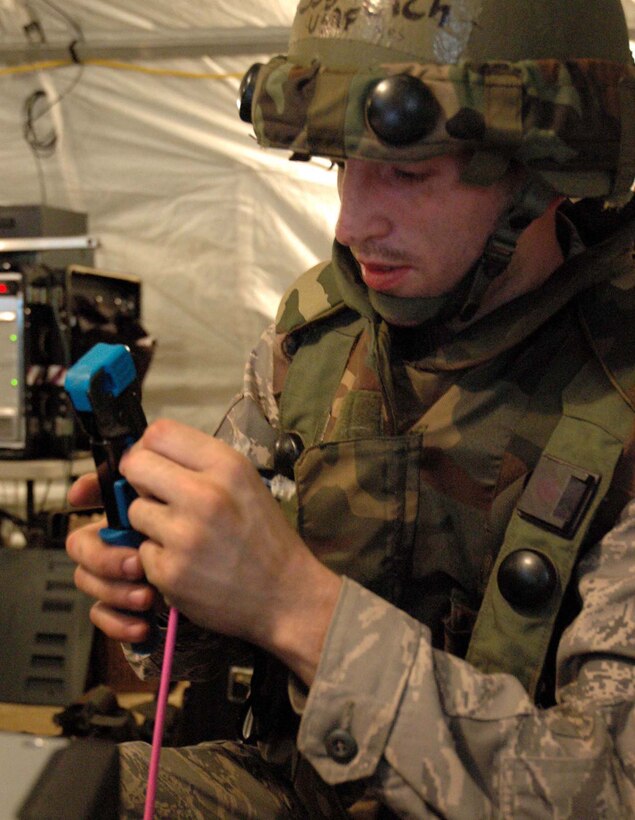 MCGUIRE AIR FORCE BASE, N.J. -- Staff Sgt. Christopher Cich a Reserve communication specialist makes telephone cables during the early stages of the recent Eagle Flag exercise held at Lakehurst Naval Air Station, Lakehurst, N.J.  Eagle Flag gives participants an opportunity to practice opening an airbase under bare base conditions. (U.S. Air Force photo/Master Sgt. Donna T. Jeffries)
