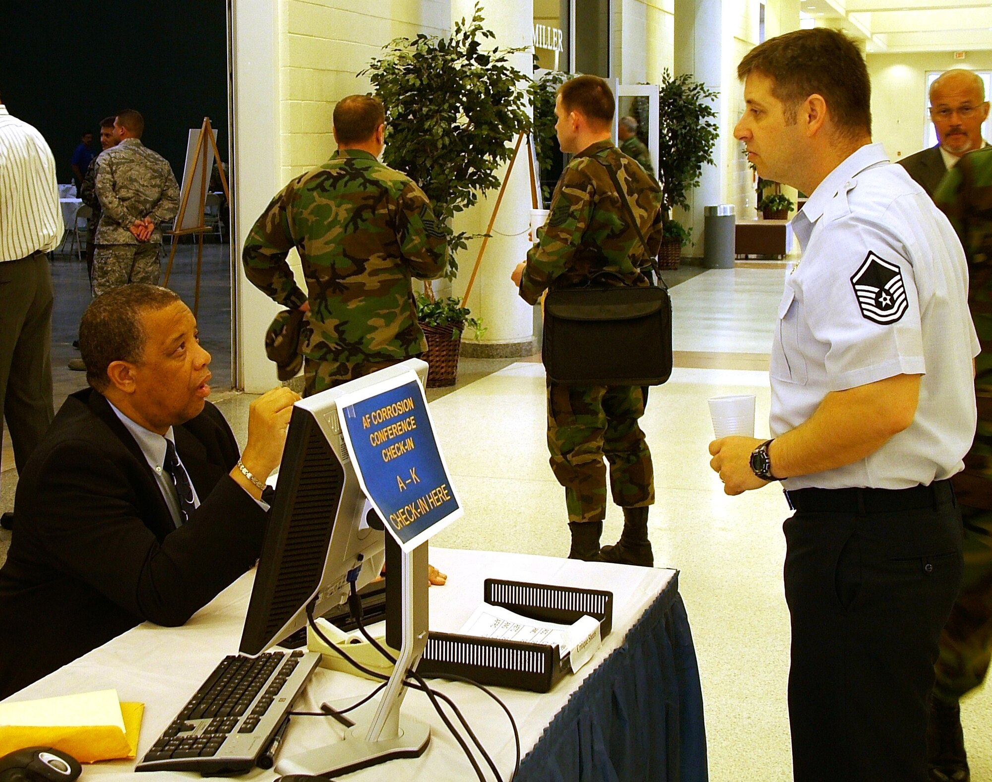 Mr. Kevin Wilson, Salish & Kootenai Technologies and a member of the Air Force Corrosion Prevention and Control Office, provides assistance to Master Sgt. Vincent Snider, Air Mobility Command corrosion manager at the 39th annual Air Force Corrosion Conference held May 13-15 at the Georgia National Fairgrounds in Perry, Georgia. (U.S. Air Force photo/2nd Lt. David Rail)