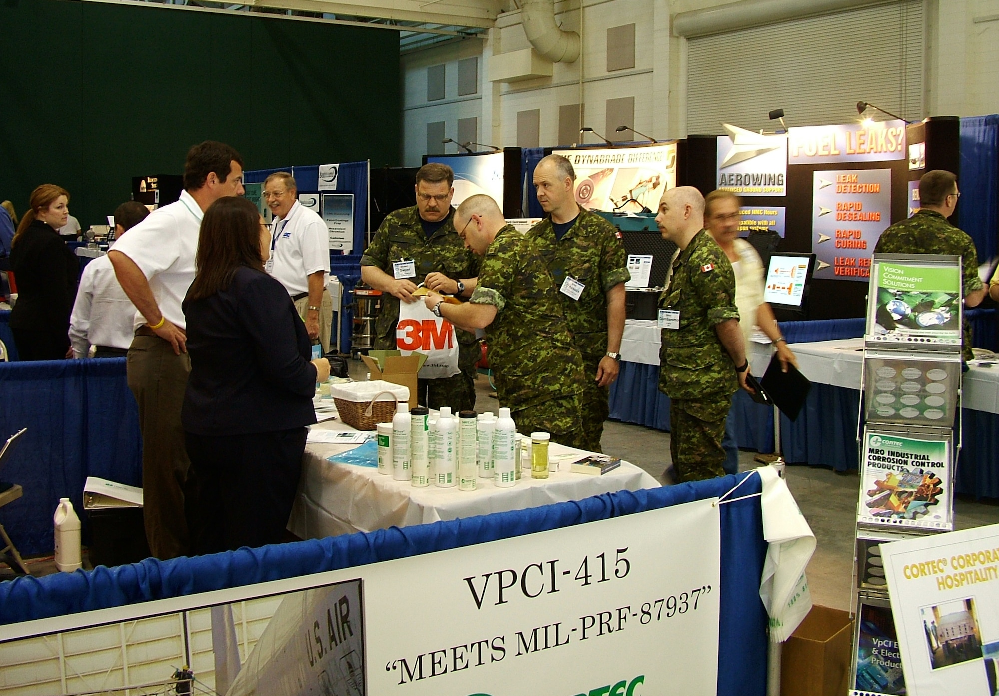 Canadian military personnel are shown interacting with vendors in the main aisle of the vendor's fair at the Air Force Corrosion Prevention and Control Office’s 39th annual Air Force Corrosion Conference held May 13-15 at the Georgia National Fairgrounds in Perry, Georgia. (U.S. Air Force photo/2nd Lt. David Rail)