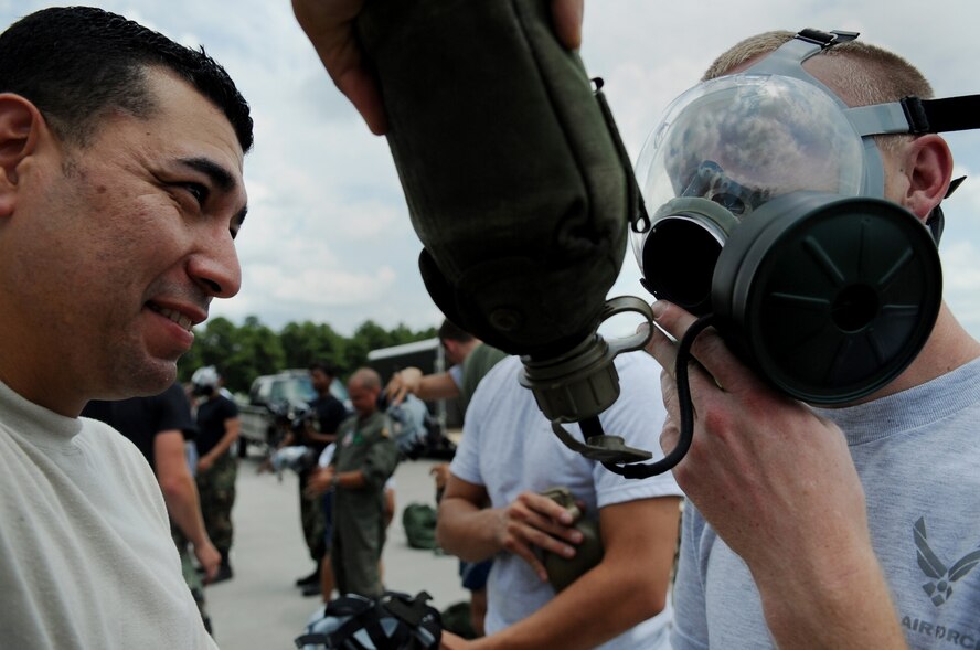 MOODY AIR FORCE BASE, Ga. -- Staff Sgt. Jose Santiago, 23rd Equipment Maintenance Squadron aircraft structural maintenance craftsman, left, helps Airman 1st Class William Gordon, 23rd EMS munitions apprentice, drink water through a tube connected to his gas mask here June 23. Airmen must complete chemical warfare courses like this periodically in preparation for deployment. (U.S. Air Force photo by Senior Airman Gina Chiaverotti) 