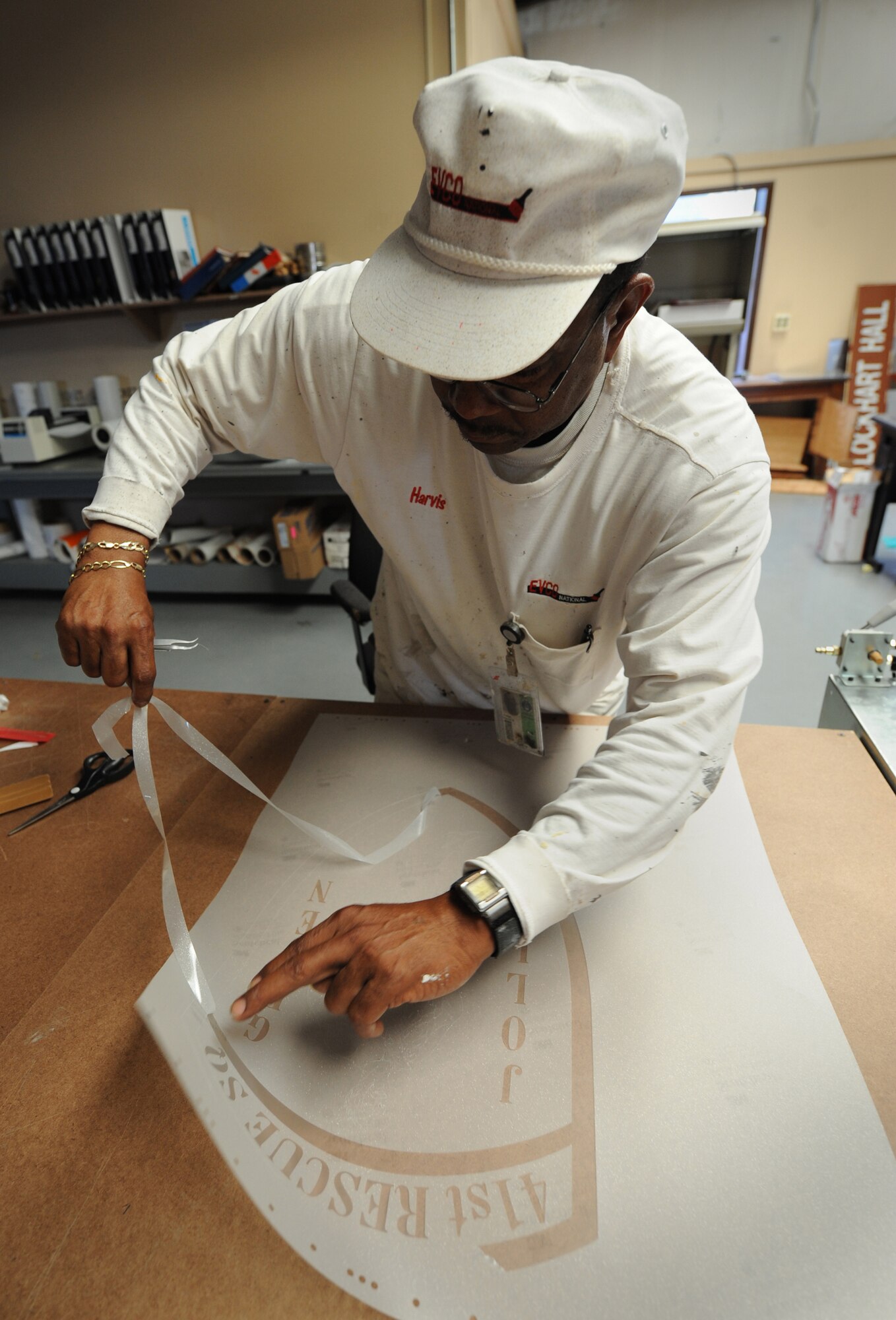 MOODY AIR FORCE BASE, Ga. -- Harvis Fluker, 23rd Civil Engineer Squadron paint shop supervisor, removes parts of a decal of the 41st Rescue Squadron patch here June 3. The decal, which is designed on a computer and printed, will look just like frosted glass when it is applied. (U.S. Air Force photo by Senior Airman Gina Chiaverotti)