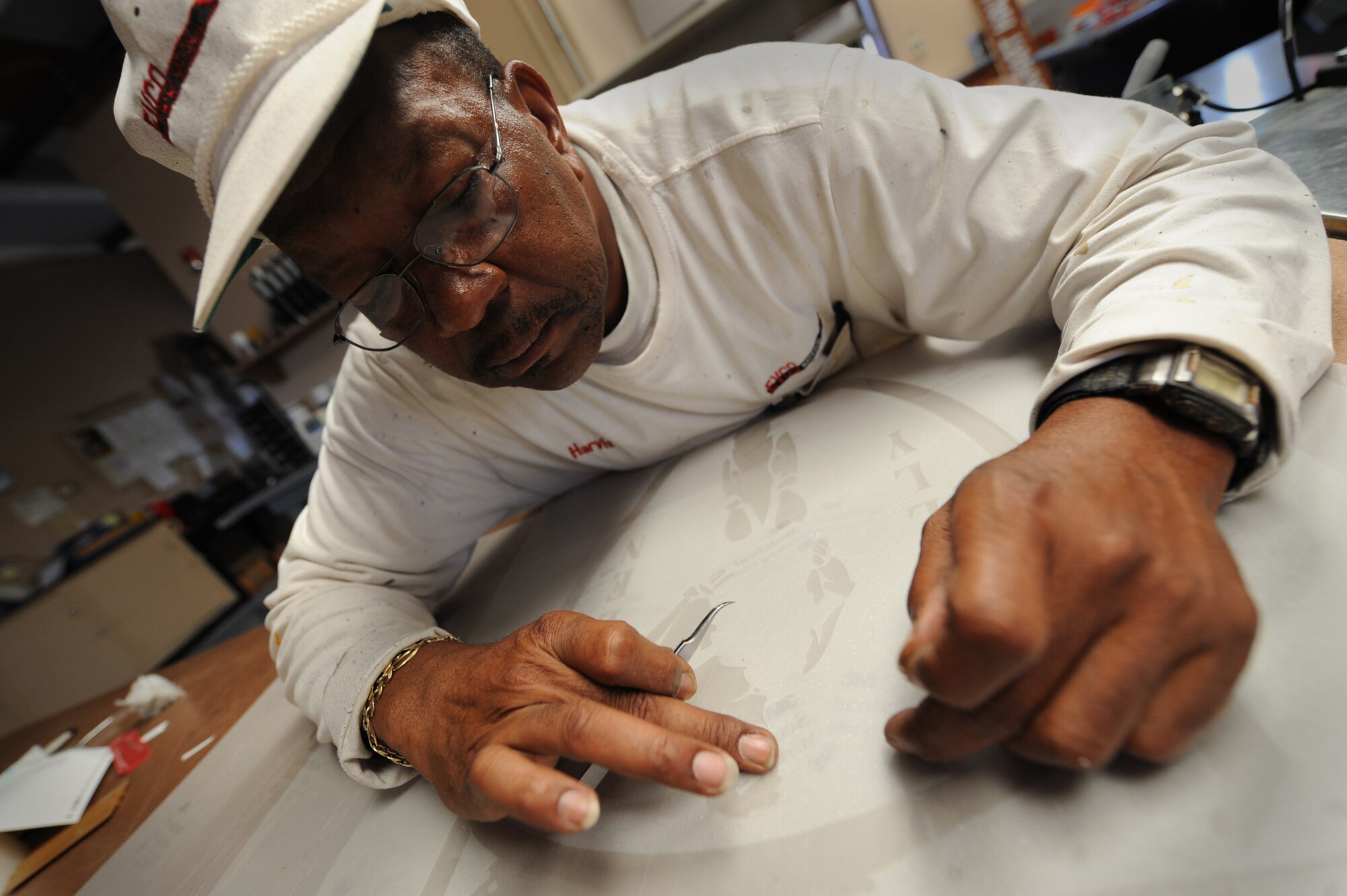 MOODY AIR FORCE BASE, Ga. -- Harvis Fluker, 23rd Civil Engineer Squadron paint shop supervisor, works on the 41st Rescue Squadron window decal here June 3. The squadron decal will be placed on a door at the squadron. (U.S. Air Force photo by Senior Airman Gina Chiaverotti)