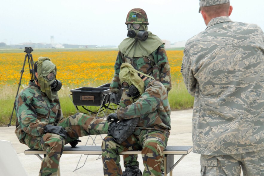 Tech. Sgt. Frank Roman observes South Korean army soldiers while they remove their chemical warfare gear June 24 at Kunsan Air Base, South Korea. South Korean army soldiers demonstrated the capabilities of their nuclear, biological and chemical detection technology during a two-day combined training session here June 23 and 24. Sergeant Roman is the NCO in charge of readiness and training from the 8th Civil Engineer Squadron. (U.S. Air Force photo/Staff Sgt Araceli Alarcon)