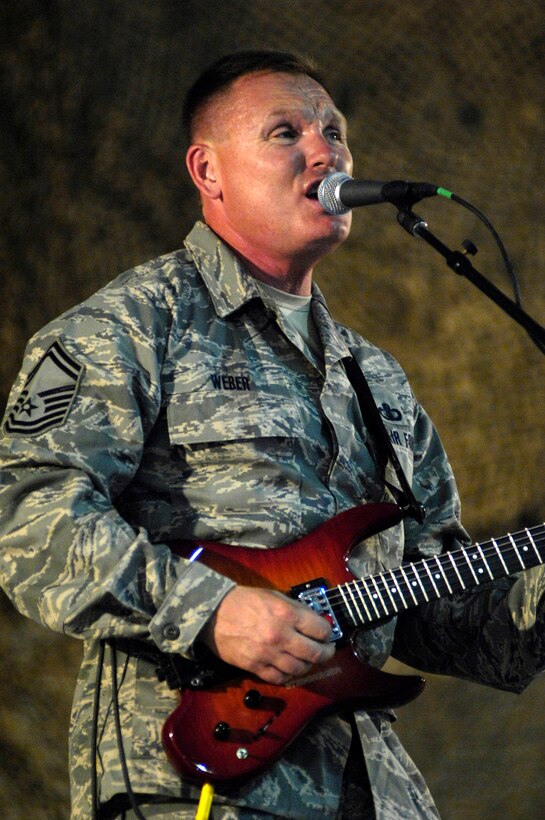 Senior Master Sgt. James Weber sings during a show June 22 at Bagram Air Base, Afghanistan. The U.S. Air Forces Central Band "Falcon" band travels throughout the area of responsibility to promote troop morale and to reach out to host nation communities. General Holmes is the 455th Air Expeditionary Wing commander. Sergeant Weber is the band's vocalist and guitarist. (U.S. Air Force photo/Master Sgt. Demetrius Lester) 