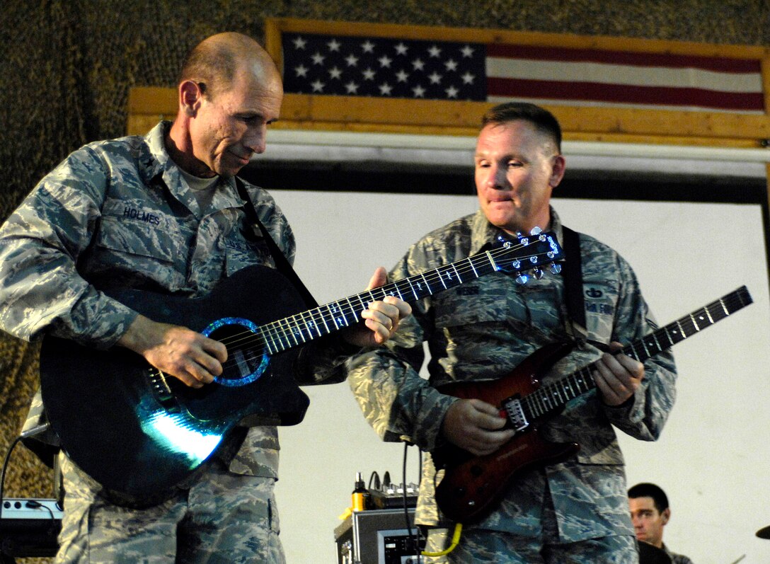 Brig. Gen. James M. "Mike" Holmes plays guitar as Senior Master Sgt. James Weber looks on during the band's show June 22 at Bagram Air Base, Afghanistan. The U.S. Air Forces Central Band "Falcon" band travels throughout the area of responsibility to promote troop morale and to reach out to host nation communities. General Holmes is the 455th Air Expeditionary Wing commander. Sergeant Weber is the band's vocalist and guitarist. (U.S. Air Force photo/Master Sgt. Demetrius Lester) 
