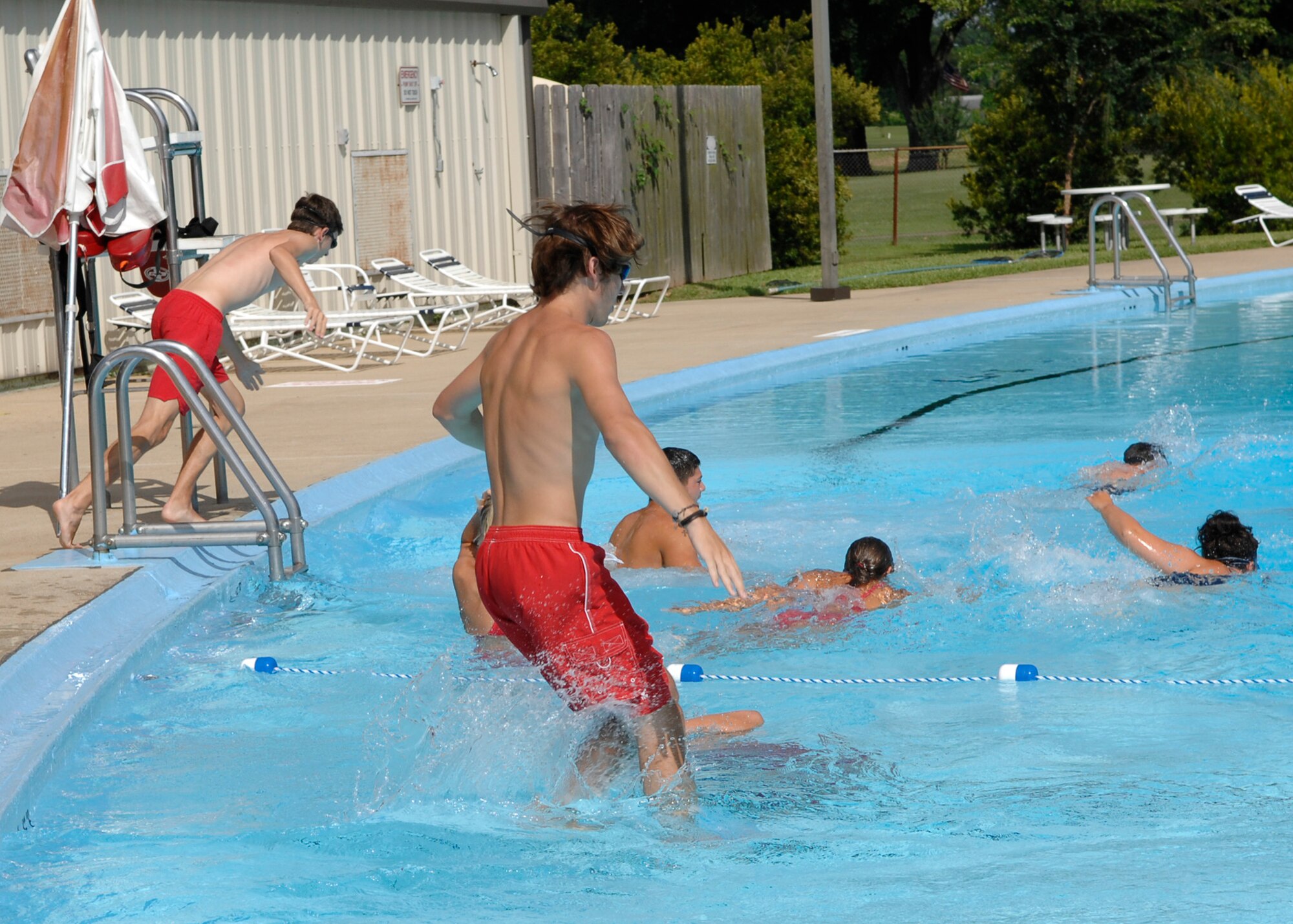 BARKSDALE AIR FORCE BASE, La. -- Lifeguards from the 2d Force Support Squadron jump in the  pool in preparation for water rescue training. The lifeguards on Barksdale support two pools ensuring the safety of patrons. Traditionally Barksdale's lifeguard positions were filled by local area college and high school students but this year there are two active-duty Airmen training and serving with their civilian counterparts. The need for active-duty lifeguards has increased because several forward deployed locations have pools, Jun. 11, 2008.  (U.S. Air Force photo by TSgt Laura K. Smith) (released)