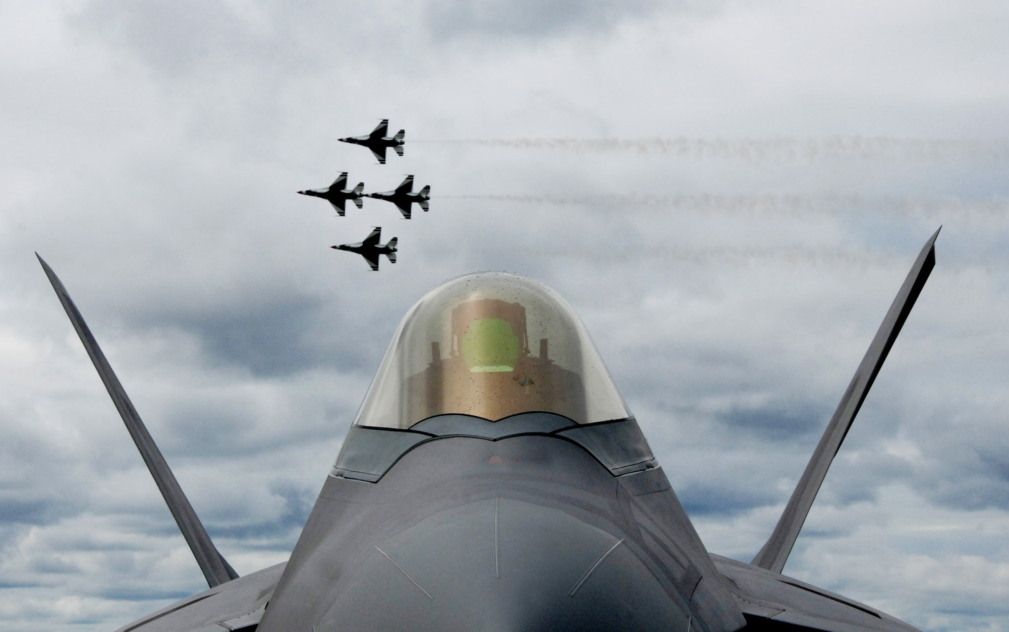 Four Air Force Thunderbird F-16 Fighting Falcons fly together in formation behind an F-22 Raptor for more than 6,000 spectators during the June 24 airshow at Eielson Air Force Base, Alaska. The "Soaring into Soltice" airshow provided an opportunity for the local community to visit and get an up close view and demostration of the capabilities of the Air Force's aircraft. (U.S. Air Force photo/Tech Sgt. Eric T. Sheler) 
